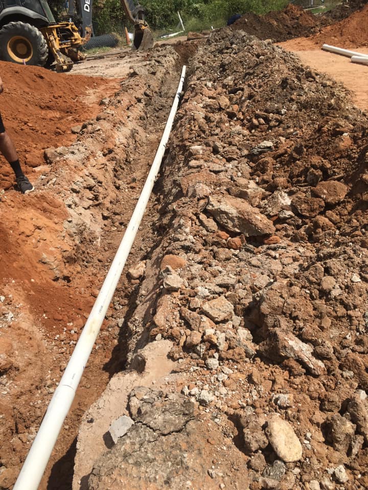 PVC drain line and gravel backfill during a conventional septic system installation near Granbury, TX